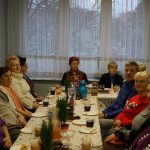 osoby siedzą przy stole i rozmawiają